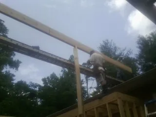 Carpenter setting a ridge beam over a new addition frame — Ice Dam Removal by Roofing Brothers in Smithsburg